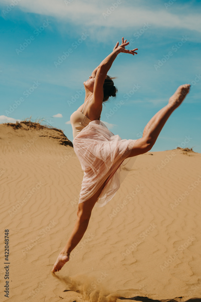 A ballerina in the desert dances beautifully