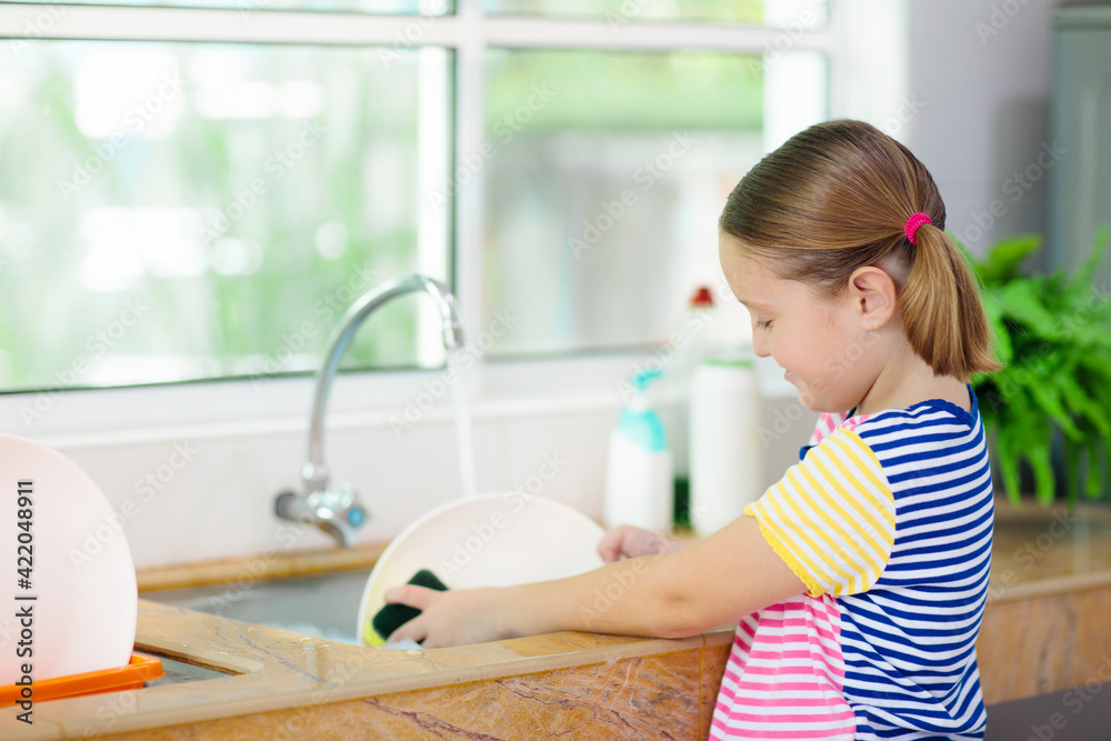Child washing dishes.