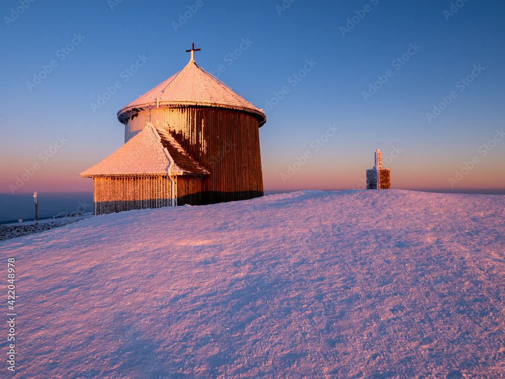 old chapel on peak of Sniezka mountain at sunset in winter in the Karkonosze Mountains in Poland