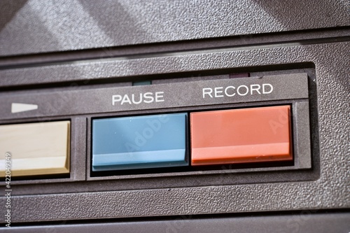 Pause and record buttons on a vintage reel to reel audio tape recorder