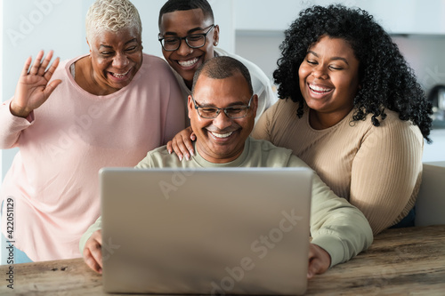 Happy black family having fun doing video call using laptop at home during corona virus outbreak - Technology and communication concept © Alessandro Biascioli