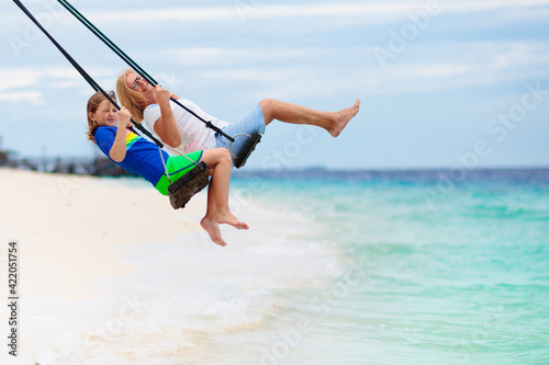 Child on beach swing. Summer vacation.