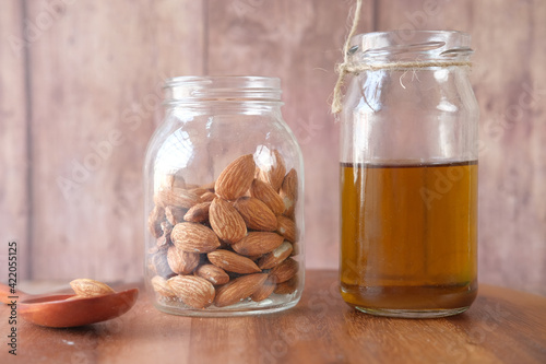 Almond oil in bottle on wooden background. top down