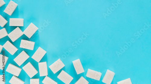 background of sugar cubes. White cube sugar on blue background. White sugar close up with copy space