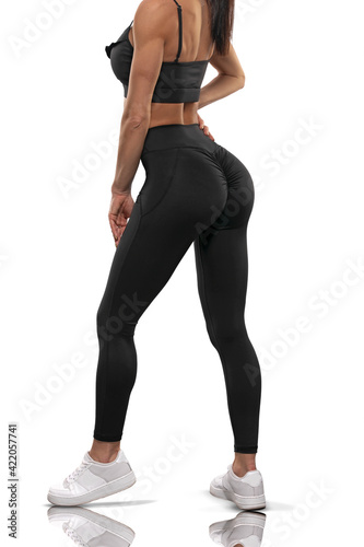 Legs girl in black leggings and a top stay back on a white background