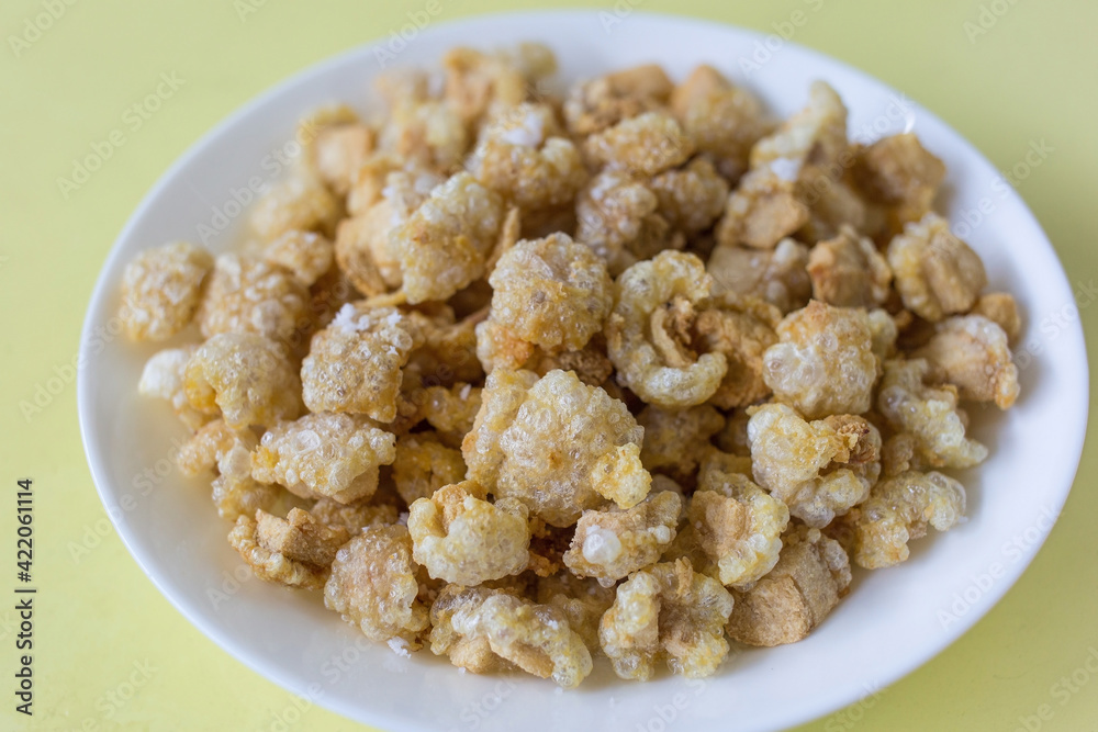 Pork crackling (pork snack, pork scratching) is fried pork skin as snack and we can eat it with noodles in Thai food style.