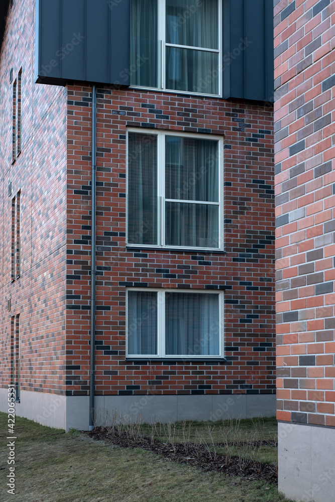 Modern apartment building with random red, brown, and gray brick wall. Freshly built residential house. Modern apartment building with random red, brown, and gray brick wall. Freshly built residential house.