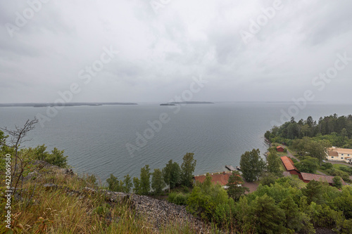 Wallpaper Mural A wonderful view from mountains to nature with a view of Baltic Sea. The tops of green forest trees against backdrop of a stormy sky on a cloudy summer day. Sweden. Torontodigital.ca