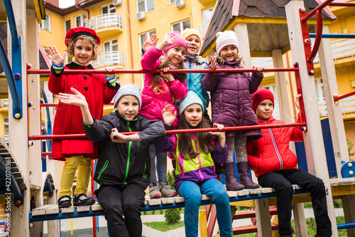 Cheerful kids at outdoor playground in early spring