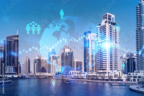 Skyscrapers of Dubai business downtown. International hub of trading and financial services. Social network icons hologram, concept of people connection. Double exposure. Dubai Canal waterfront.