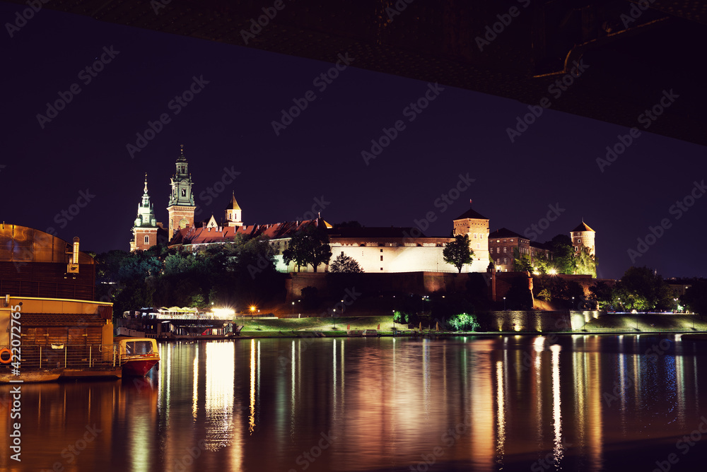Night view on Wawel Castle in Cracow. Beautiful reflections in Wisla river, citylights directed towards the castle.