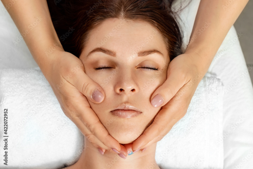 Facial massage close-up. Young, beautiful girl at spa procedures. Skin care, oriental massage treatments, beauty treatments. Facial massage close-up. Young, beautiful girl at spa procedures. Skin care, oriental massage treatments, beauty treatments.
