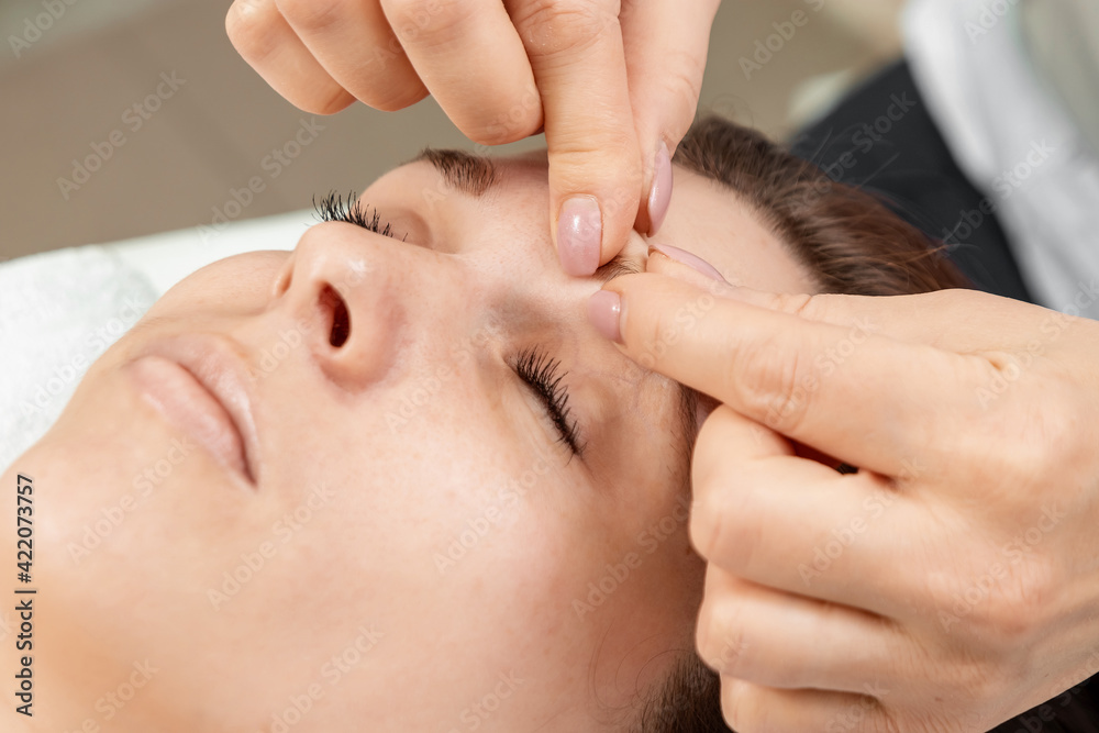 Facial massage close-up. Young, beautiful girl at spa procedures. Skin care, oriental massage treatments, beauty treatments. Facial massage close-up. Young, beautiful girl at spa procedures. Skin care, oriental massage treatments, beauty treatments.
