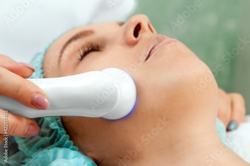 Medical, cosmetological procedure for the treatment of facial skin with light, phototherapy for cleansing the pores on the face. Skin care, cosmetic procedures.