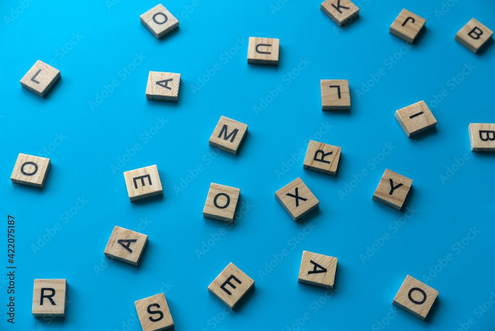 Wooden alphabet on blue background.