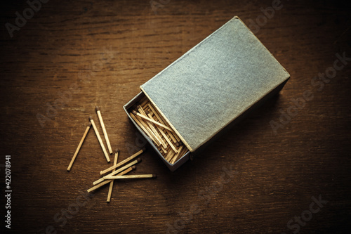 A large cardboard box of matches on a wooden table