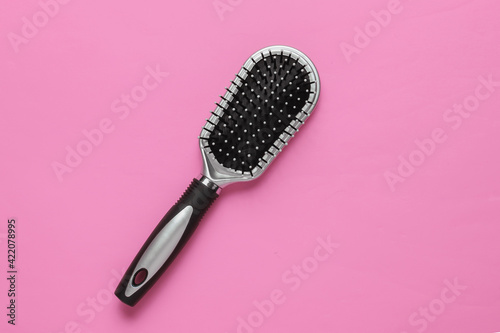 Stylish hairbrush on pink background. Women's Hair Care Accessories.