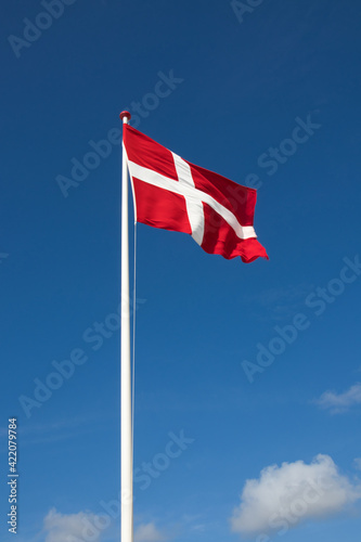 The danish flag with blue sky on background