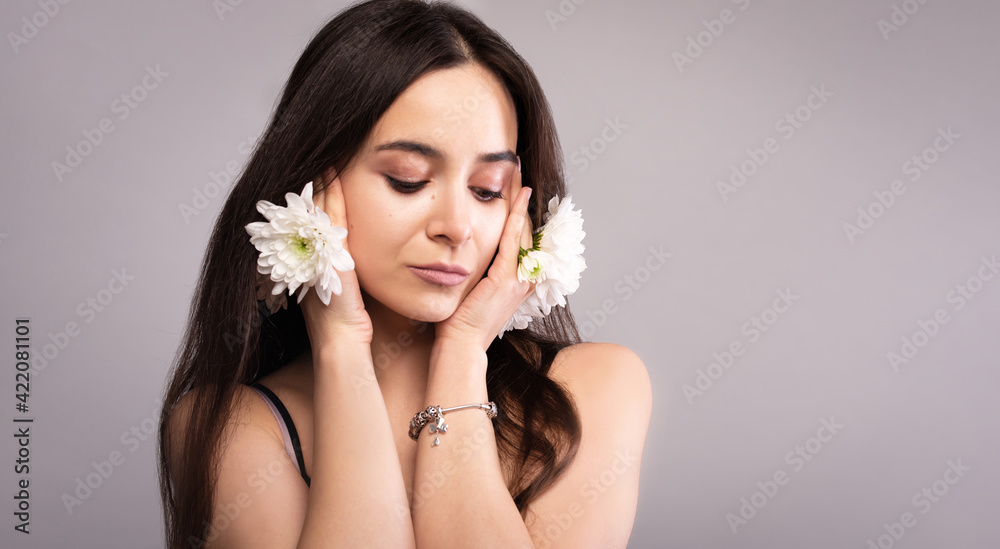 Portrait of a beautiful natural natural blue-eyed girl with white flowers in the wild. Nude make-up.