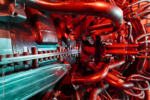 A modern gas turbine aircraft engine in a futuristic red-green light. © Alexander