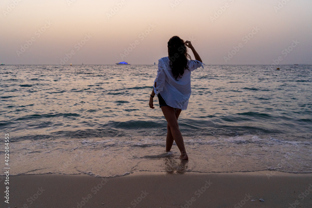 Woman at the beach during the sunset