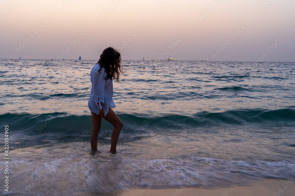 Woman at the beach during the sunset Woman at the beach during the sunset