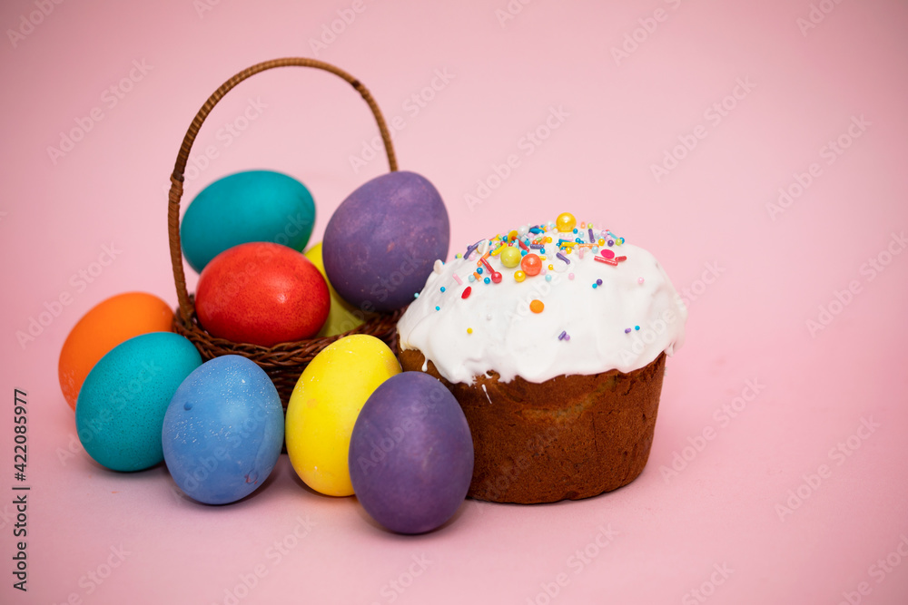 Small basket with beautiful colorful Easter eggs and Easter cakes Small basket with beautiful colorful Easter eggs and Easter cakes