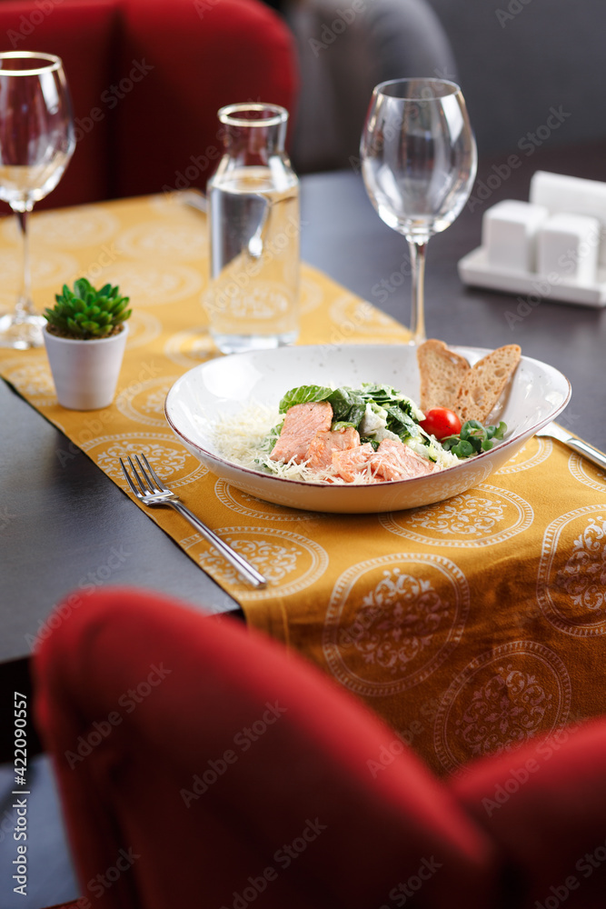 Plate of salad with red fish with glass of still water