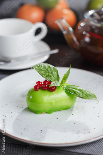 Green colored dessert with basil served with teapot