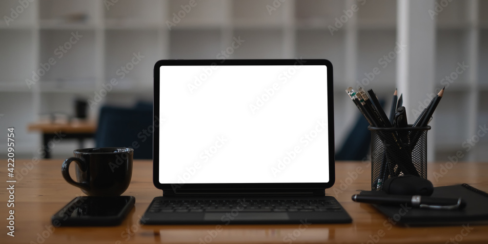 Fototapeta premium White blank screen tablet on modern working desk.
