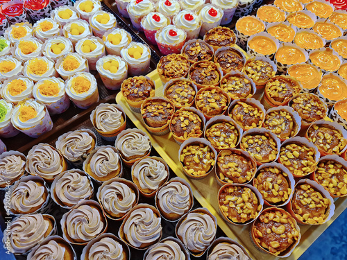 Various Kinds of Colorful Cupcakes with Different Toppings for Sale