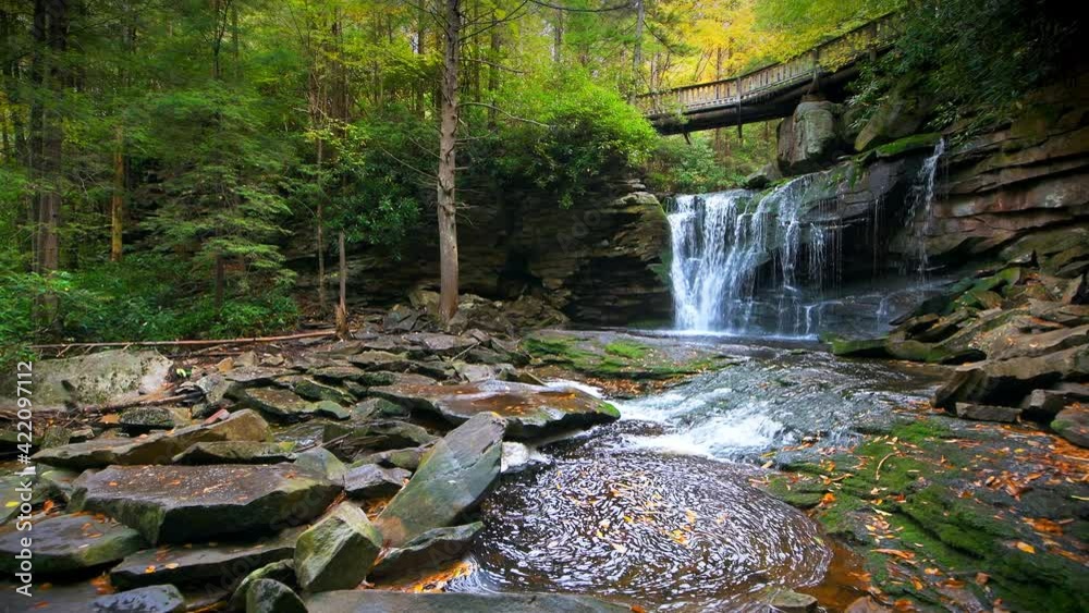 Point of view pov handheld walking shot of Elakala waterfall in Blackwater Falls state park, West Virginia in fall autumn with red maple leaves foliage