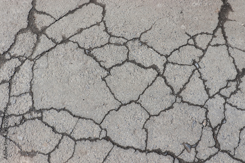Cracked asphalt background. Old pavement texture with cracks. 