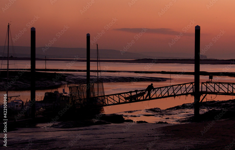 Twilight image  of boats and jetty in silhouette on  an English estuary