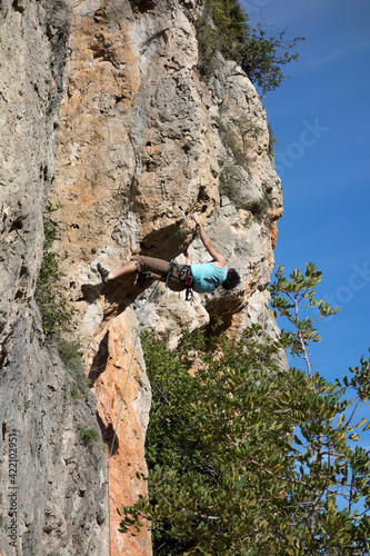 man climbing a mountain with rope