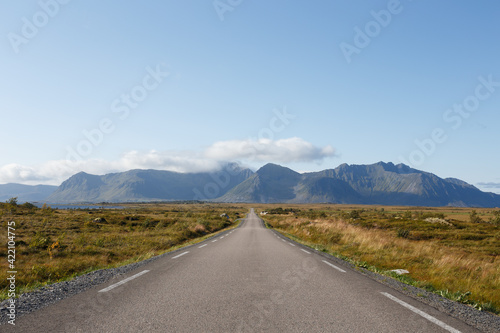 Road leading into the horizon with mountain in the background in Gimsoy, Lofoten, Norway