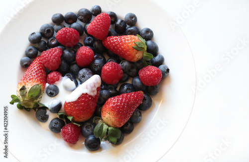 Frutta fresca. Lamponi  mirtilli e fragole freschi su un piatto bianco. Direttamente sopra.