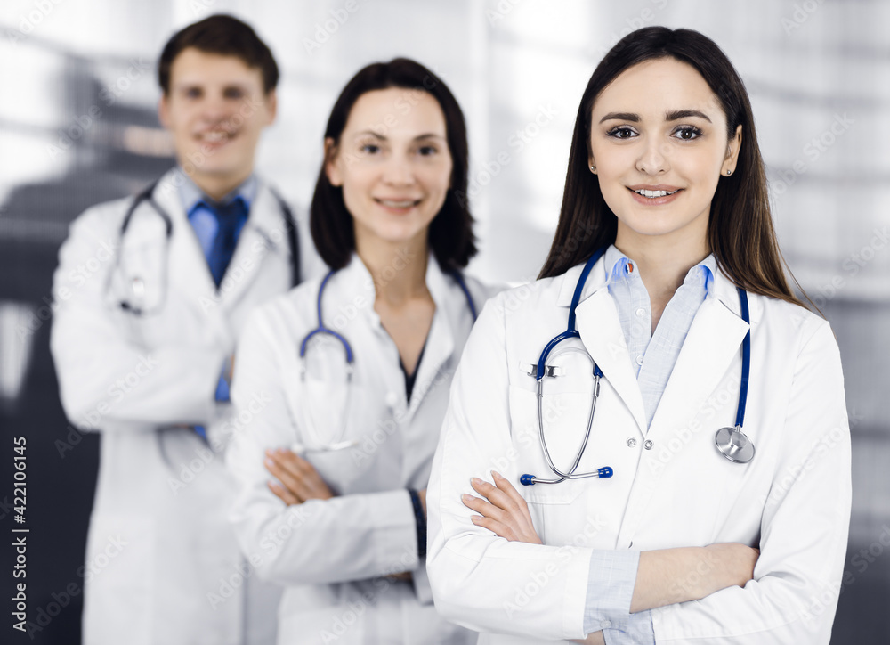 Group of young professional doctors is standing as a team with arms crossed in a hospital office and is ready to help patients. Medical help, insurance in health care, best disease treatment and Group of young professional doctors is standing as a team with arms crossed in a hospital office and is ready to help patients. Medical help, insurance in health care, best disease treatment and