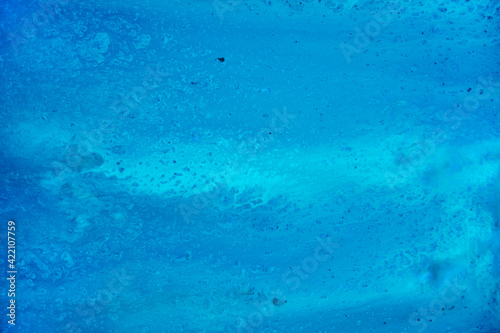 A blue texture reminiscent of water or ocean. Watercolor paints © Viktoriia