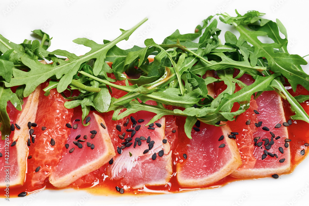 Salmon served with a grapefruit sauce, arugula and black sesame seeds Salmon served with a grapefruit sauce, arugula and black sesame seeds