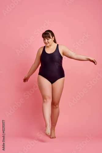 Overweight woman poses in swimsuit, body positive
