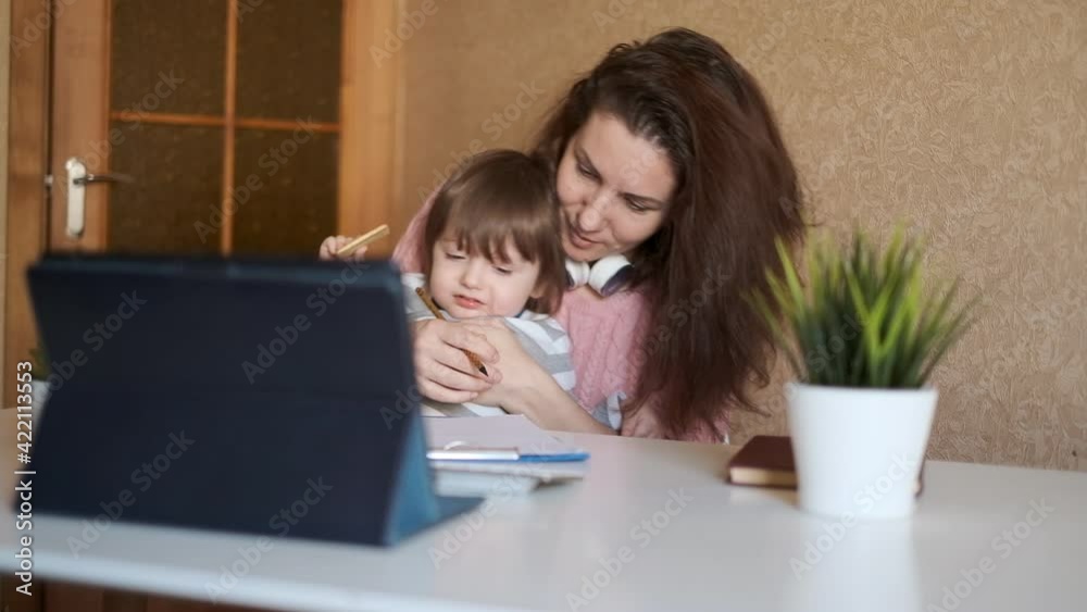 Online education. Young woman with small child trying to learn English online. Tired young mom is getting online education. Online education. Young woman with small child trying to learn English online. Tired young mom is getting online education.