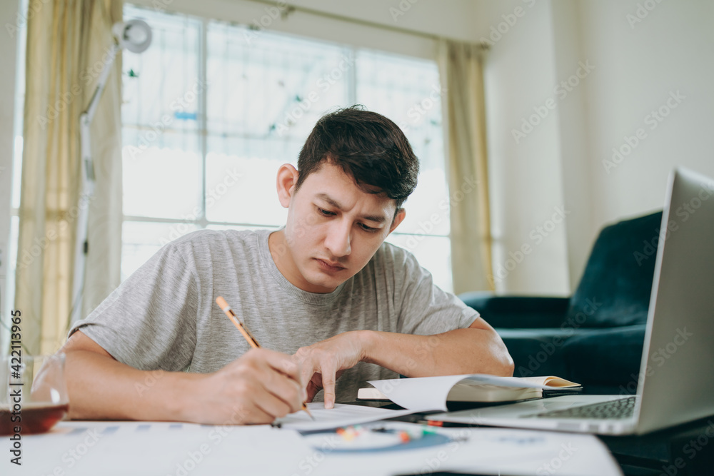 Young Businessman working at home with paper graph and data. Business and freelance concept.