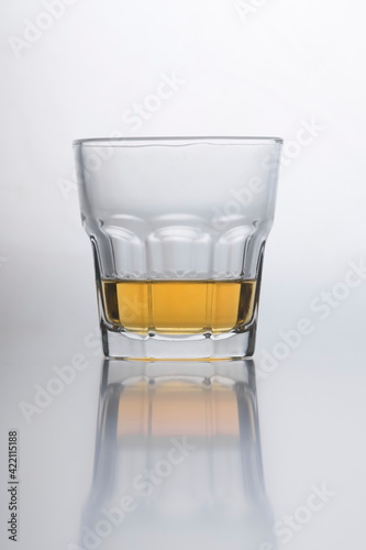Whiskey in the glass reflecting on smooth surface