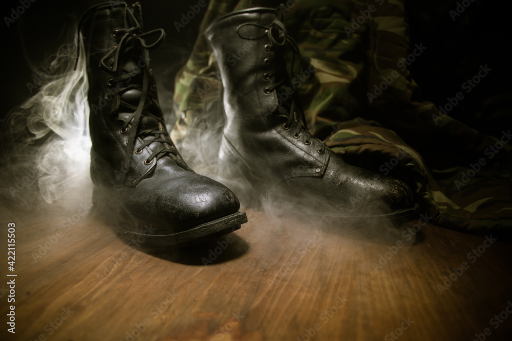 War concept. Old military shoe in a dark toned foggy background. Creative concept of conflict between countries, military aggression.