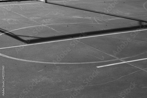 lines of the ground of a basketball field  white lines on gray asphalt  there are painted with chalk on the ground