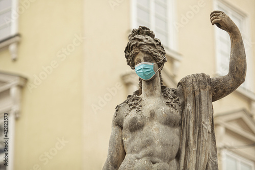 Coronavirus, Bio Protection Concept. Statue of Greek goddess Amphitrite with medical mask in European city. Copy-space. Outdoor shot