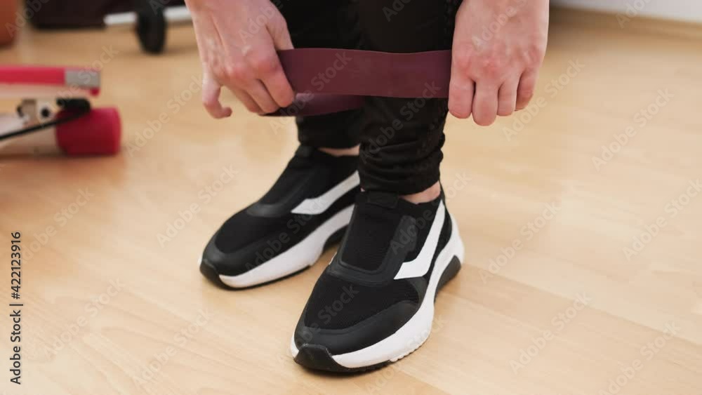 Woman applying fitness elastic band for training at home. Woman applying fitness elastic band for training at home.