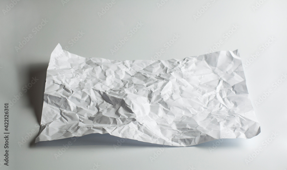 A crumpled blank sheet of paper. On a white background. Dented