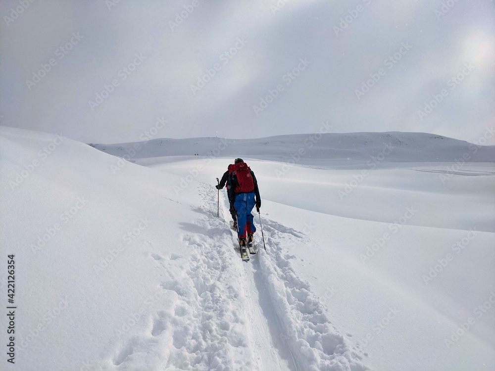 Ski tours in the Glarus region. Pure winter landscape with snowy trees with the ascent trail and snowfall.Mountaineering Ski tours in the Glarus region. Pure winter landscape with snowy trees with the ascent trail and snowfall.Mountaineering